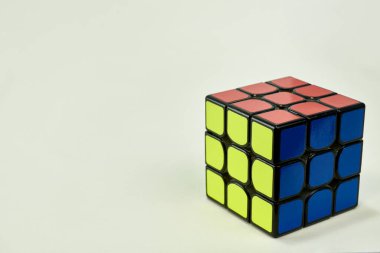 Beyaz zemin üzerinde mavi, sarı ve turuncu rubik küpü çözüldü.