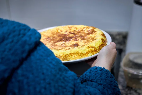 İspanyol patatesli omlet tutan tanınmamış bir kadın.
