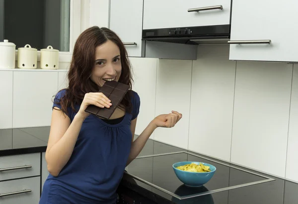 Young woman biting a block of dark chocolate — Stock Photo, Image