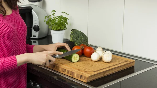 Woman cutting a cucumber — Stock Photo, Image