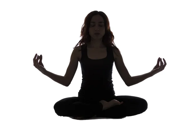 Silhouette of a young woman in meditation pose — Stock Photo, Image