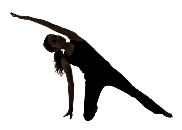 Vrouw die zich uitstrekt van haar kant lichaam in yoga, silhouet — Stockfoto