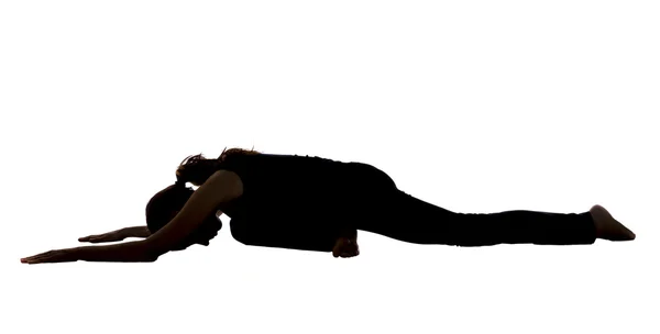 Silhouet van een jonge vrouw in duif pose in yoga — Stockfoto