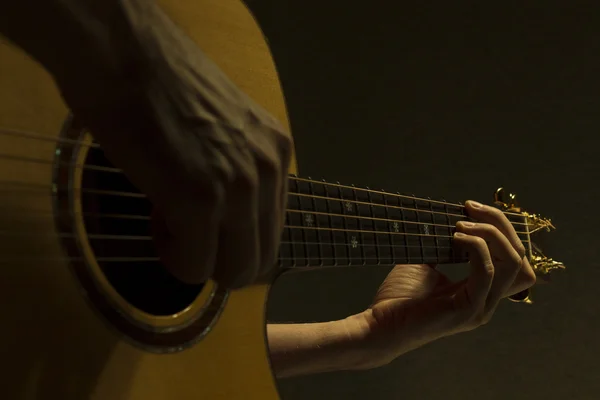 Acoustic guitar under dramatic light — Stock Photo, Image