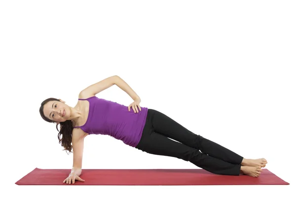 Mujer haciendo una variación de la pose de tablón lateral —  Fotos de Stock