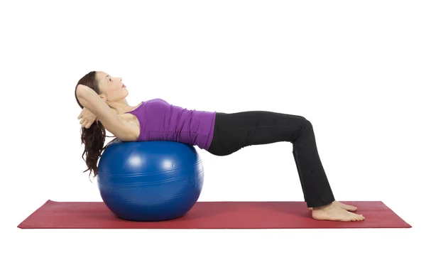 Mujer joven haciendo crujir en la pelota de pilates — Foto de Stock