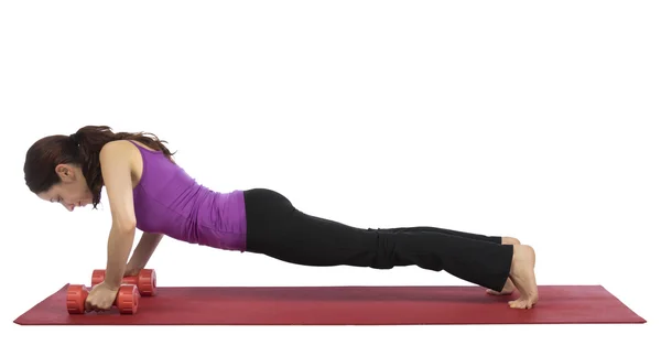 Woman in plank pose with dumbbells — Stock Photo, Image