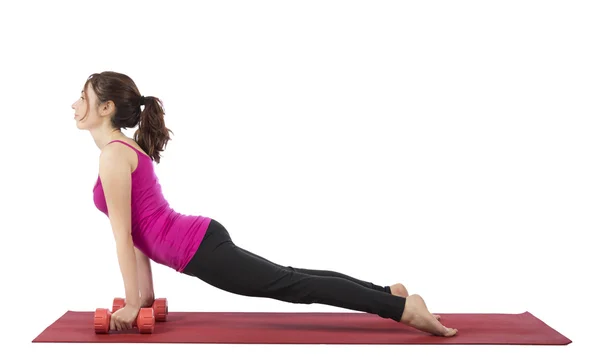 Young woman doing upward facing dog with dumbbells — Stock Photo, Image