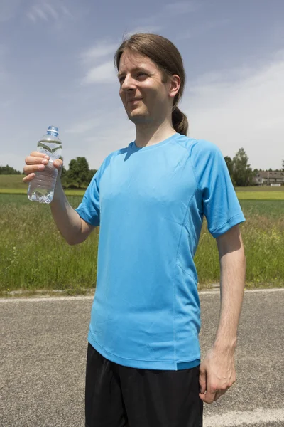 Jogger man med en flaska vatten — Stockfoto