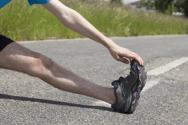 Closeup of a jogger stretching his legs — Stockfoto