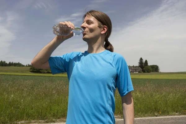 Jogger man refreshing during workout outdoors — Stock Photo, Image