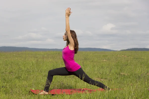 Женщина делает воина я позирую на открытом воздухе во время йоги — стоковое фото