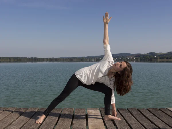 Kvinnan gör en variant av utökad vinkel utgör under yoga — Stockfoto