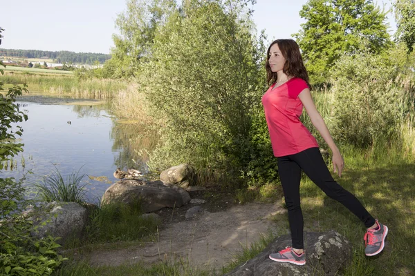 Jeune femme joggeuse étirant dans la nature — Photo