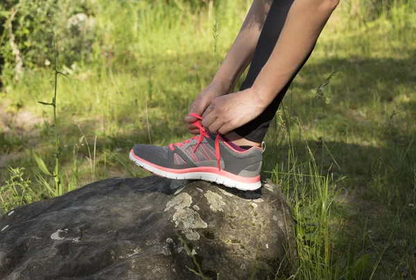 Frau schnürt ihre Sportschuhe — Stockfoto