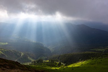 Güneş ışınları bulutların arasından dağların arka planında kırılıyor. Maramures Dağları, Pip Ivan Dağı, Ukrayna. Canlı fotoğraf duvar kağıtları.