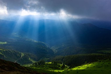 Güneş ışınları bulutların arasından dağların arka planında kırılıyor. Maramures Dağları, Pip Ivan Dağı, Ukrayna. Canlı fotoğraf duvar kağıtları.