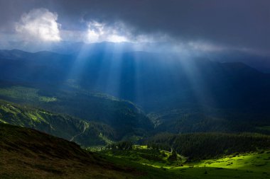 Güneş ışınları bulutların arasından dağların arka planında kırılıyor. Maramures Dağları, Pip Ivan Dağı, Ukrayna. Canlı fotoğraf duvar kağıtları.