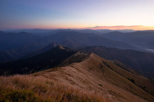Karpatlar 'da, Ukrayna' nın Gorgan bölgesindeki dolambaçlı bir dağ sırası manzaralı büyülü bir günbatımı. Turizm ve dağ konsepti.