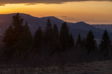 Karpat Dağları 'nda parlayan bir gökyüzüyle bir akşam. Ufukta parlak bir akşam gökyüzü olan Karpat dağlarının manzarası.