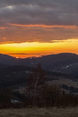 Karpat Dağları 'nda parlayan bir gökyüzüyle bir akşam. Ufukta parlak bir akşam gökyüzü olan Karpat dağlarının manzarası.