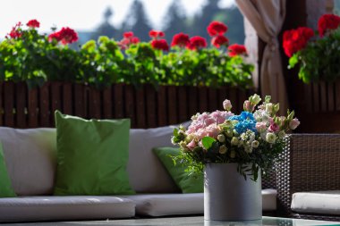 A rose bouquet in a box on a summer terrace. A bouquet of pink and white roses decorated in a hat box created by a florist.