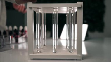 Bir bilim adamı siyah bir kimyasal reaktörü açık bir sıvı şişesine damlatıyor. Kimyasal siyah reaktör, temiz bir sıvıyla test tüpünde yavaşça erir. Ağır çekim. Yakın plan.