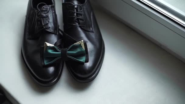 绿色领结的特写躺在黑色经典皮鞋上 美丽的绿色婚礼蝴蝶的头像 — 图库视频影像