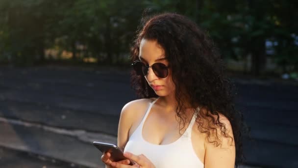 Young Caucasian Girl Black Sunglasses Wearing White Top Texting Phone — Stock Video