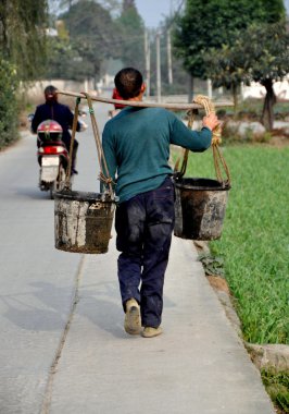 China: Farmer Carrying Water Buckets in Pengzhou clipart