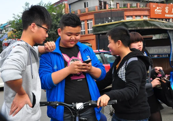 Čínské teenager kontrola jeho mobil v pengzhou — Stock fotografie