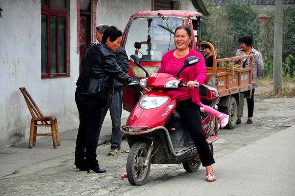 China: Mulher na motocicleta conversando com os vizinhos — Fotografia de Stock