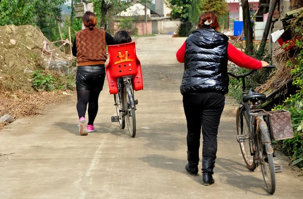 China: vrouwen lopen fietsen op landweg in pengzhou — Stockfoto