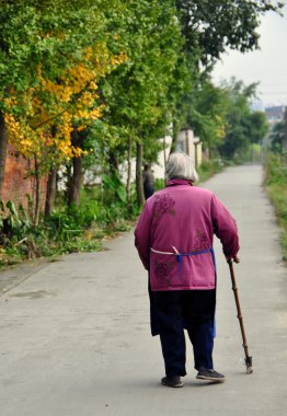 China: Old Woman Walking on Country Road clipart