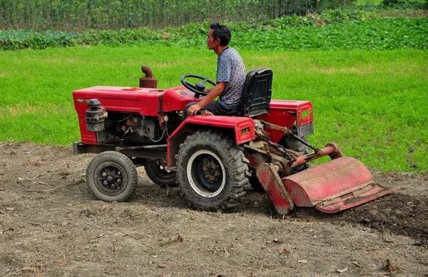中国： 农夫在拖拉机犁耕字段 — 图库照片