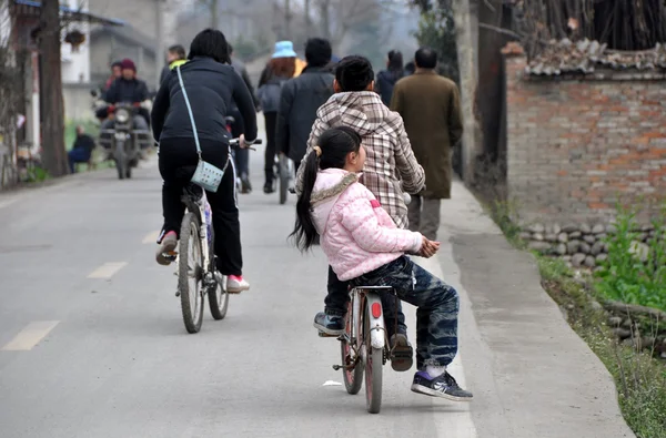 China: Gente montando bicicletas en un camino rural — Foto de Stock