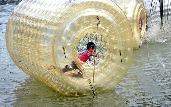 Pengzhou, China: Niño jugando dentro del tambor de agua de plástico inflado —  Fotos de Stock