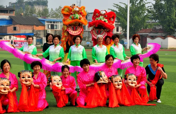 Pengzhou, Kina: costumed kinesiska kvinnor och lion dansare — Stock fotografie