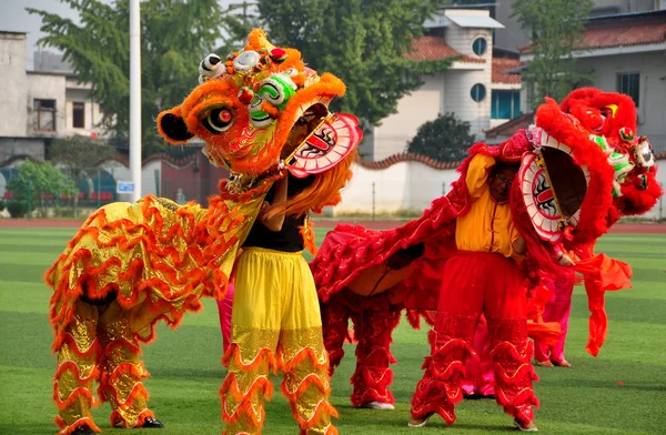 Pengzhou, Chiny: czerwony i oranged lew tancerzy — Stockfoto