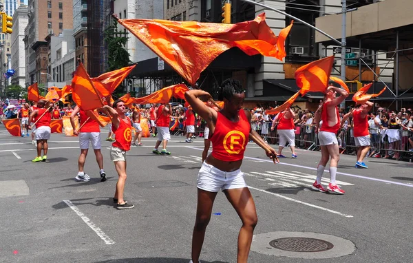 NYC: demonstranter snurrande orange flaggor på gay pride-paraden — Stockfoto