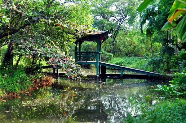 Samut prakan., thailand: träbro över tropiska trädgård lagun — Stockfoto