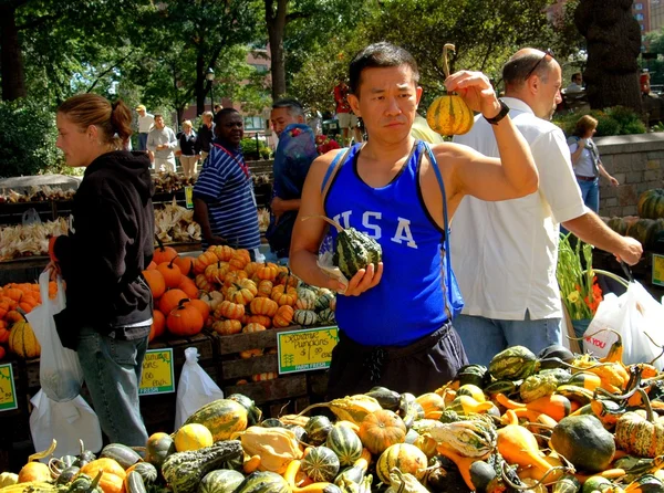 Nyc: Mann kauft Kürbisse auf Bauernmarkt — Stockfoto