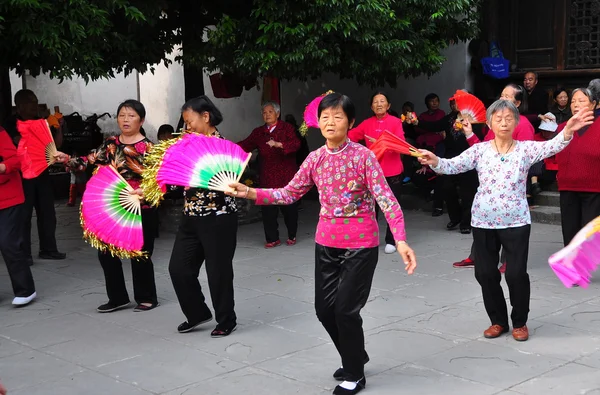 Ланчжун, Китай: танцуют женщины с розовыми и красными фанатами — стоковое фото