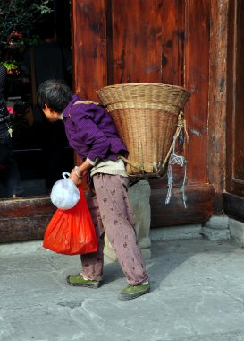 Langzhong, Çin: yaşlı kadın arka sepet taşıma