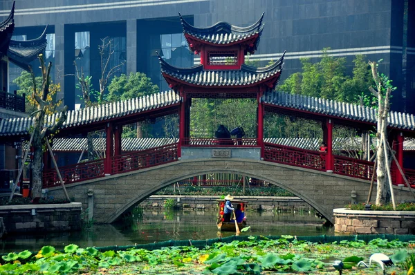 Chengdu, Çin: kadın direkleri tekne uzun kahverengi su Şehir Köprüsü altında — Stok fotoğraf