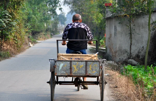 彭州市，中国： 农民的乡村道路上骑他的自行车车 — 图库照片