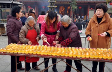 pengzhou, Çin: kadın ve uzun XING Manastırı, yanan mumlar