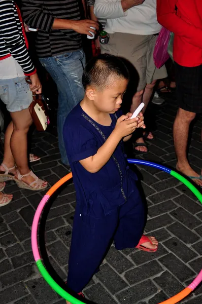 Chiang Mai, Tailandia: Niño pequeño con teléfono celular y aro Hula — Foto de Stock