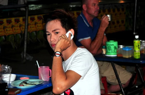 Чианг Мбаппе, Таиланд: молодой тайский мужчина пользуется мобильным телефоном — стоковое фото