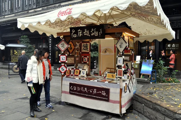 Chengdu, Kina: kinesiska flickor shopping på en jin li gatan kalligrafi monter — Stock fotografie